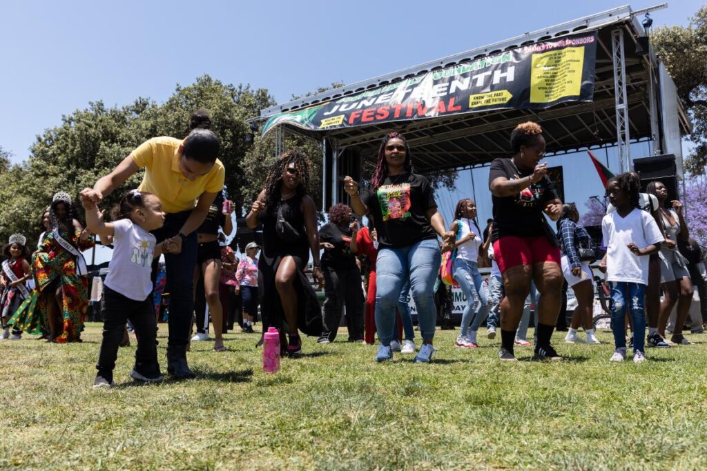 Attendees dance to “Cupid Shuffle” during the Cooper Family Foundation’s Juneteenth celebration at Memorial Park in the Logan Heights neighborhood on Saturday, June 17, 2023. (Kristian Carreon/For The San Diego Union-Tribune)